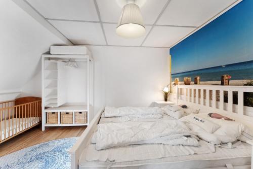 a bedroom with a large bed and a crib at Insel Hus in Fehmarn