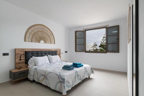 a white bedroom with a bed and a window at Casita Lanzarote in Teguise