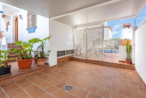 an empty room with plants and a large window at Villa Zoe in Nerja