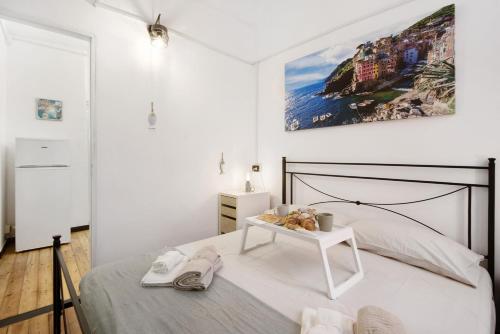 a white bedroom with a bed and a table at Apartment baia del silenzio beach in Sestri Levante