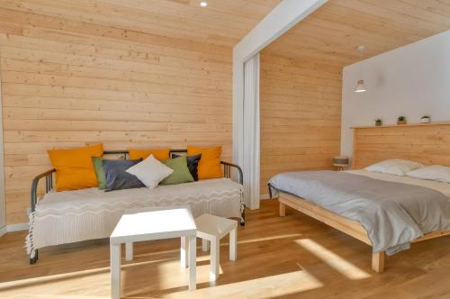 two beds in a room with wooden walls at La Dune de Sable - Cavaro in Pornichet