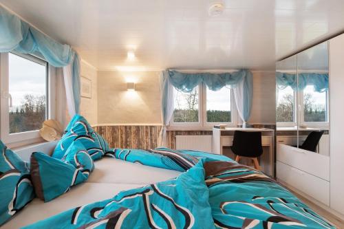 a bedroom with a large bed with blue sheets at kernsaniertes Ferienhaus Anna in Durlangen