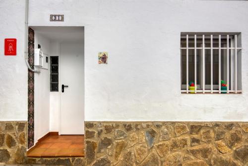 a white building with a door and a window at Casa Rural San Antón in Quesa