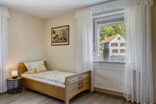 a small bedroom with a bed and a window at Mentel´s Ferienwohnung in Knüllwald