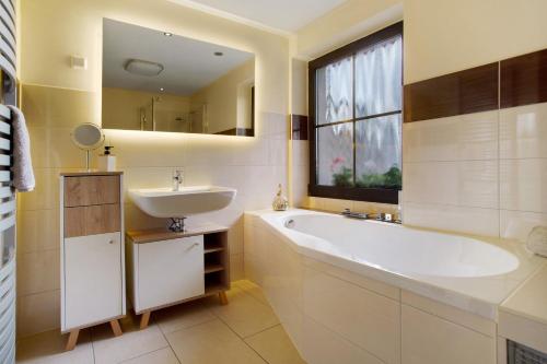 a bathroom with a tub and a sink and a window at Ferienwohnung To Hus in Putbus