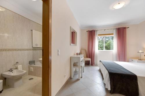 a bedroom with a bed and a sink and a toilet at Palmeiras Reais 110 in Portimão