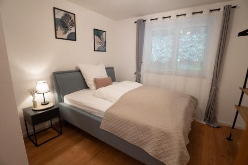 a small bedroom with a bed with a window at Wohnung im Rheintal in Küssaberg