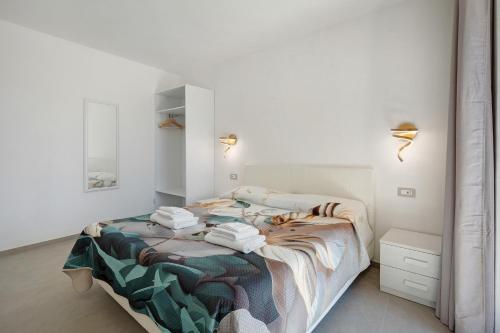 a white bedroom with a bed with towels on it at Residence Sulla Costa in Agerola