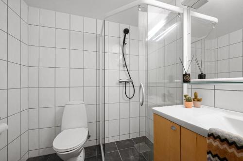 a white bathroom with a toilet and a shower at Harmony Apartments - Stavanger Sentrum 2 in Stavanger