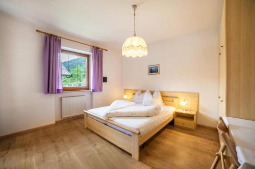 a bedroom with a bed and a window with purple curtains at Sonnenparadies Apartement 1 in Saltusio