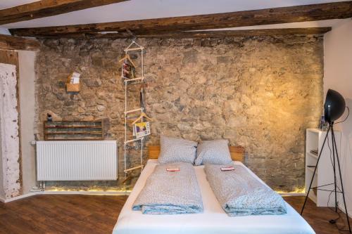 a bedroom with a bed in front of a stone wall at Fewo Sankt Johann I in Konstanz