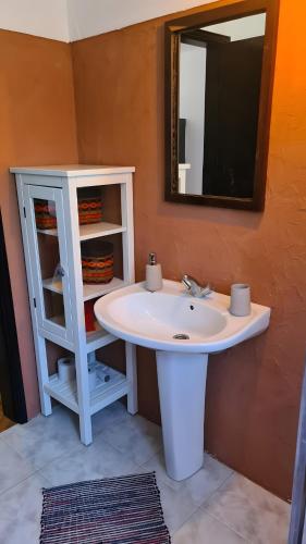 a bathroom with a white sink and a mirror at Baobab Moz Lodge in Adail