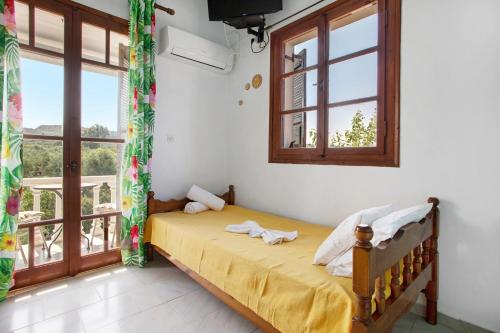 a bedroom with a bed in a room with windows at Areti Orfeas Budget Studio in Vasilikos
