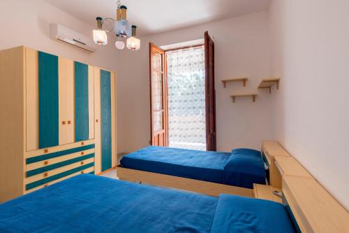 a bedroom with two beds and a window at Casa Viola 1 piano 100 mt dal mare in Trappeto