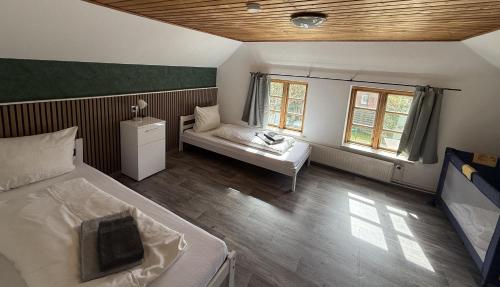 a bedroom with a bed and a couch and two windows at Ferienhaus Stemmert in Gelting