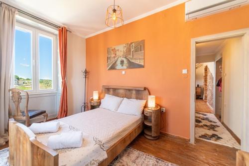 a bedroom with a bed with an orange wall at Contessa di Corfu i in Corfu