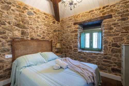 a bedroom with a bed with towels on it at La Caseta De Laura in Arzúa