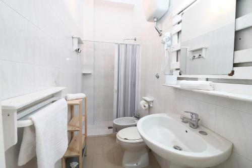a white bathroom with a sink and a toilet at Casa Vacanza Primitivo di Manduria in Otranto