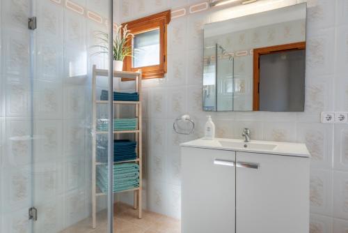 a bathroom with a sink and a mirror at Es Cantó in Cala Llombards
