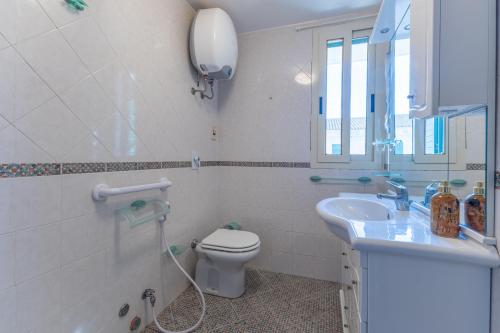 a bathroom with a toilet and a sink and a mirror at Vista Mare in Santa Croce Camerina
