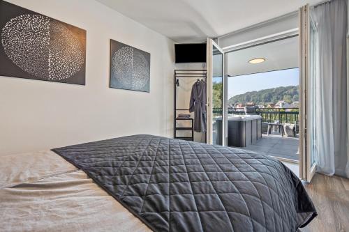a bedroom with a large bed and a balcony at Egge Resort 7c mit Whirpool u Sauna in Altenbeken