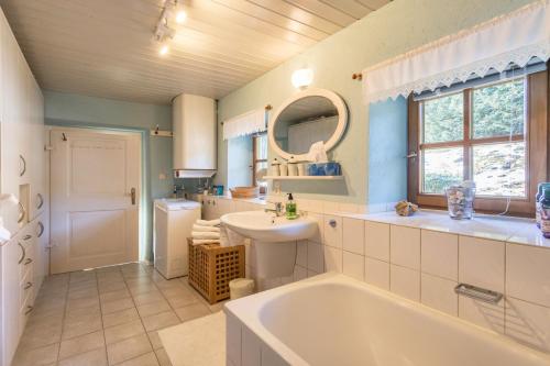 a bathroom with a tub and a sink at Uriges Landhäuschen in Siegsdorf