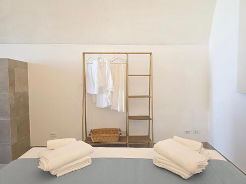 a room with a mirror and a bed with towels at Syrenia Home in Vico Equense