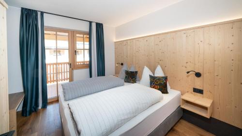 a bedroom with a white bed and a window at Himml Schlosshof in Völs am Schlern
