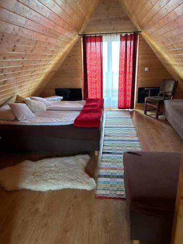 a bedroom with a large bed with red curtains at Dolina Skawy in Skawa