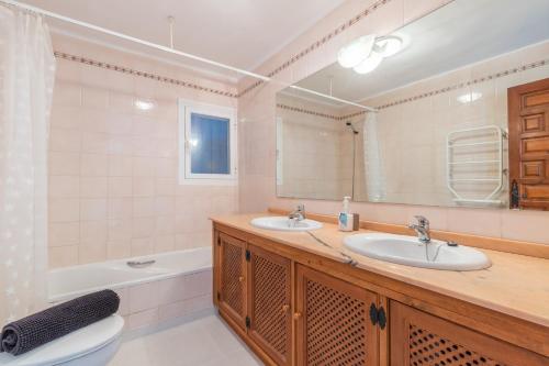 a bathroom with two sinks and a toilet and a mirror at Villa Andes in Benissa