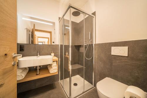 a bathroom with a shower and a sink and a toilet at Apt Eiche - Nockerhof in Andrian