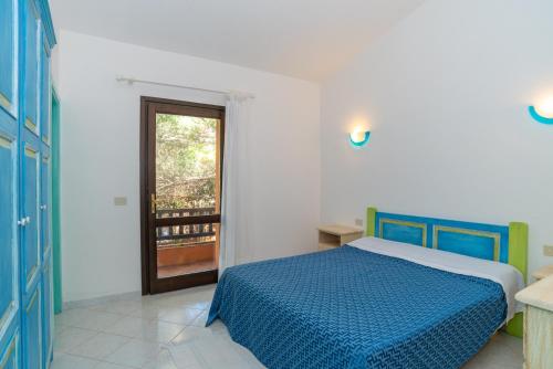 a bedroom with a blue bed and a window at Conchiglia Blu in Barrabisa