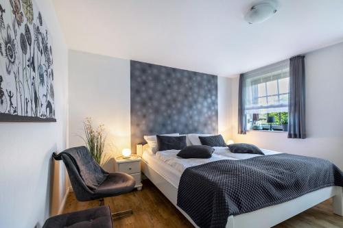 a bedroom with a bed and a chair and a window at Ferienwohnung Butjes in Sollwitt