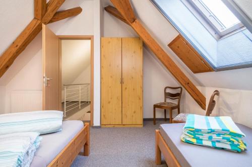 a attic bedroom with two beds and a skylight at Ferienwohnung Nr 2 in Deggenhausertal