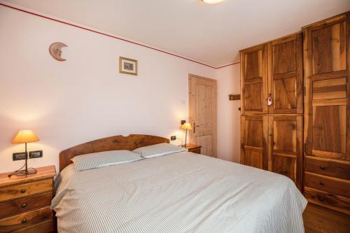 a bedroom with a large bed and a wooden cabinet at Appartamento Le Coccinelle in Varena
