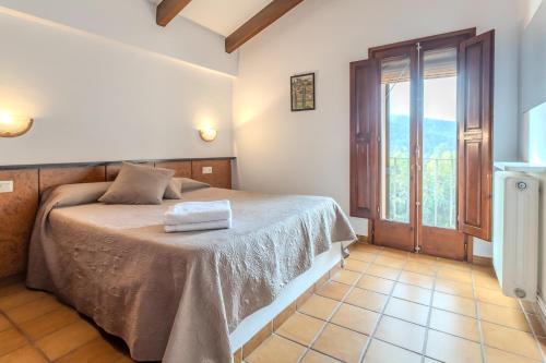 a bedroom with a bed and a large window at Can Mestrehumà in Bas