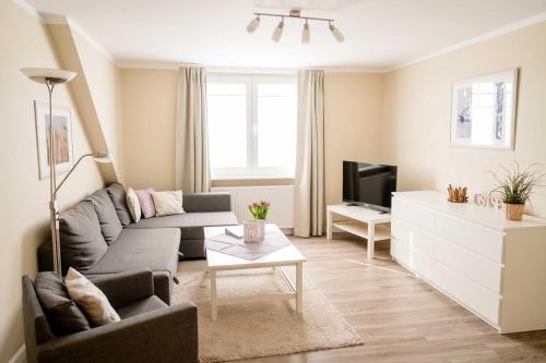a living room with a couch and a tv at Bauernhof Marquardt in Fehmarn