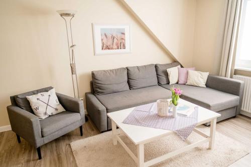 a living room with a couch and a table at Bauernhof Marquardt in Fehmarn
