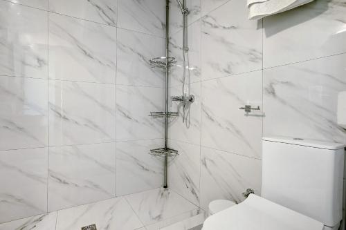 a white bathroom with a shower with a toilet at Villa Drosia in Volímai