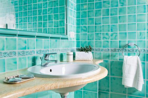 a bathroom with a sink and blue tiles at Belvedere in San Teodoro
