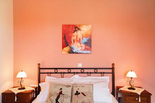 a bedroom with a bed with a painting on the wall at Lakis Apartment in Meganisi