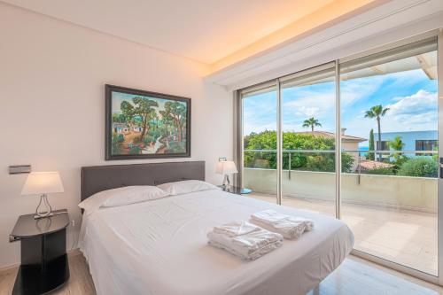 a bedroom with a white bed and a large window at Villa Agusmar in Llucmajor