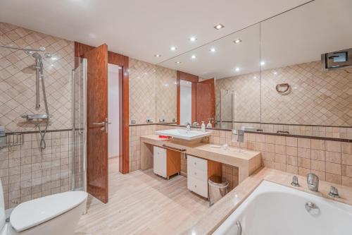 a bathroom with two sinks and a tub and a toilet at Villa Agusmar in Llucmajor
