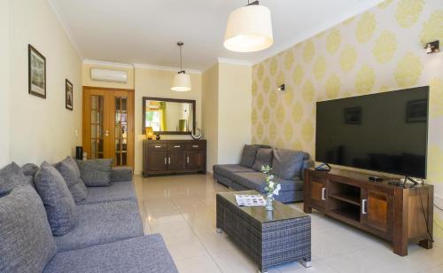 a living room with couches and a flat screen tv at C15 - The Patio do Convento Apartment in Lagos
