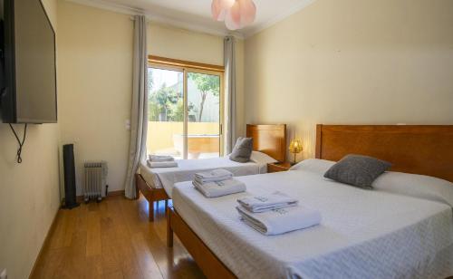 a bedroom with two beds with towels on them at C15 - The Patio do Convento Apartment in Lagos