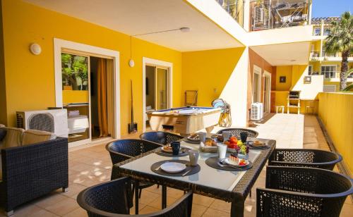 a patio with a table and chairs and a kitchen at C15 - The Patio do Convento Apartment in Lagos
