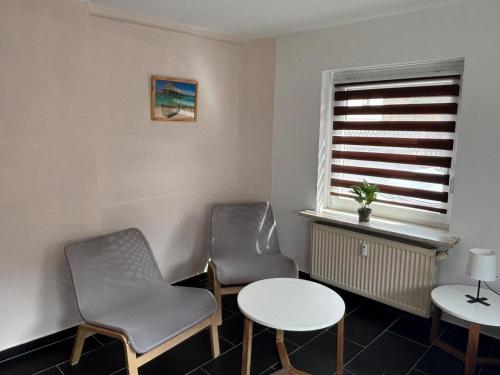 two chairs and a table in a room with a window at Ferienapartment Dörfles-Esbach in Dörfles