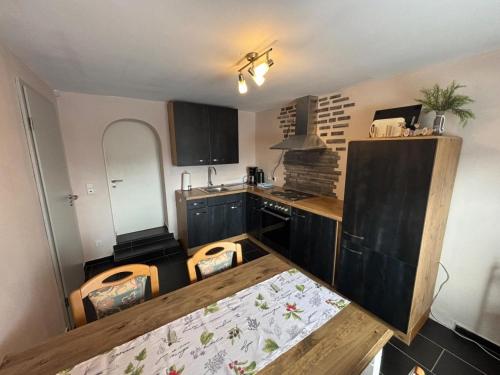a kitchen with black cabinets and a wooden counter top at Ferienapartment Dörfles-Esbach in Dörfles