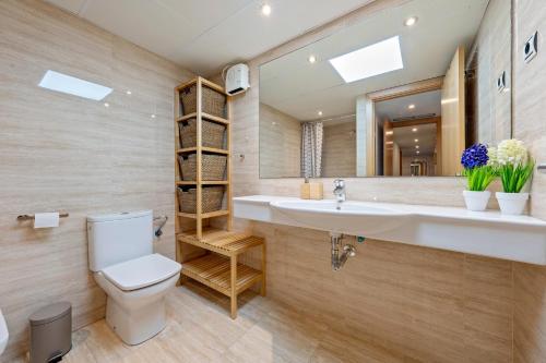 a bathroom with a sink and a toilet and a mirror at Cambrils Platja in Cambrils