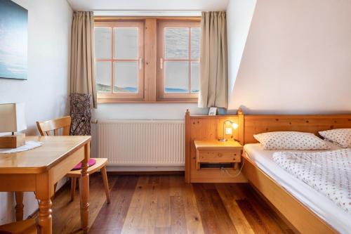a bedroom with a bed and a desk and a window at Ringlihof in Horben